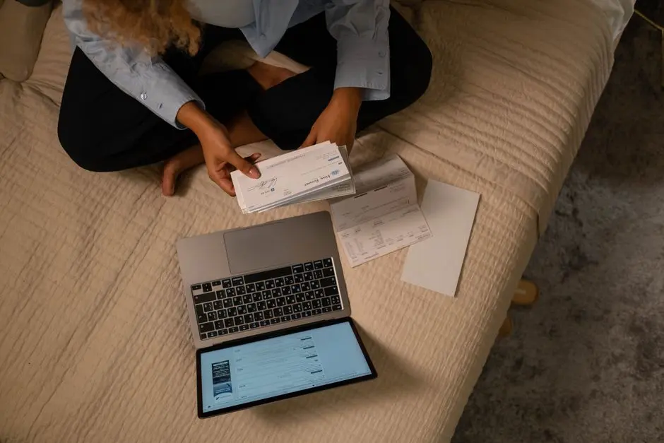 Renter reviewing bills and paperwork next to a laptop