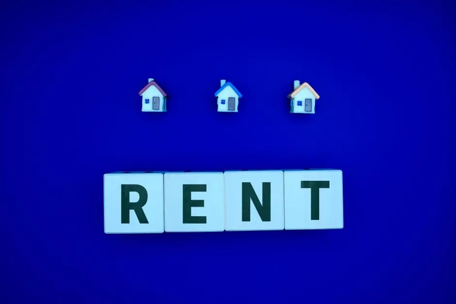 RENT spelled on blocks with three miniature houses