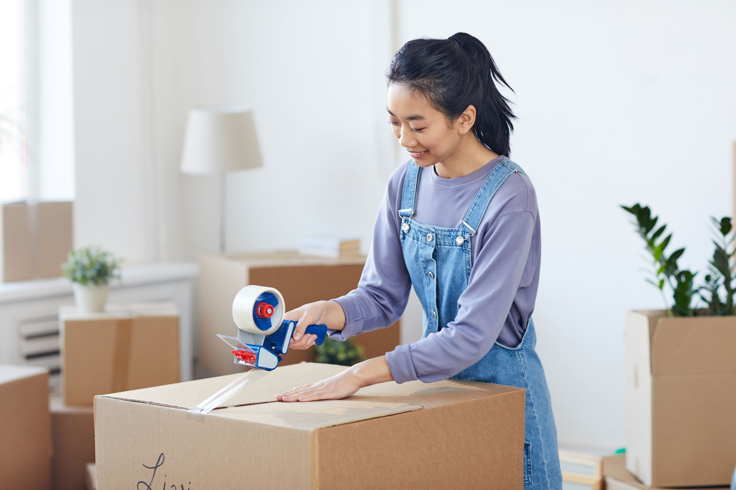 young woman moving out, packing boxes